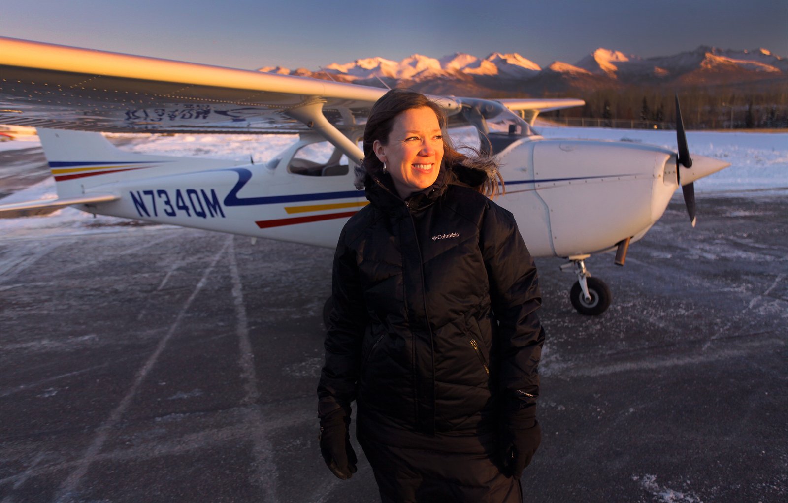 Woman pilot standing in front of her training aircraft.