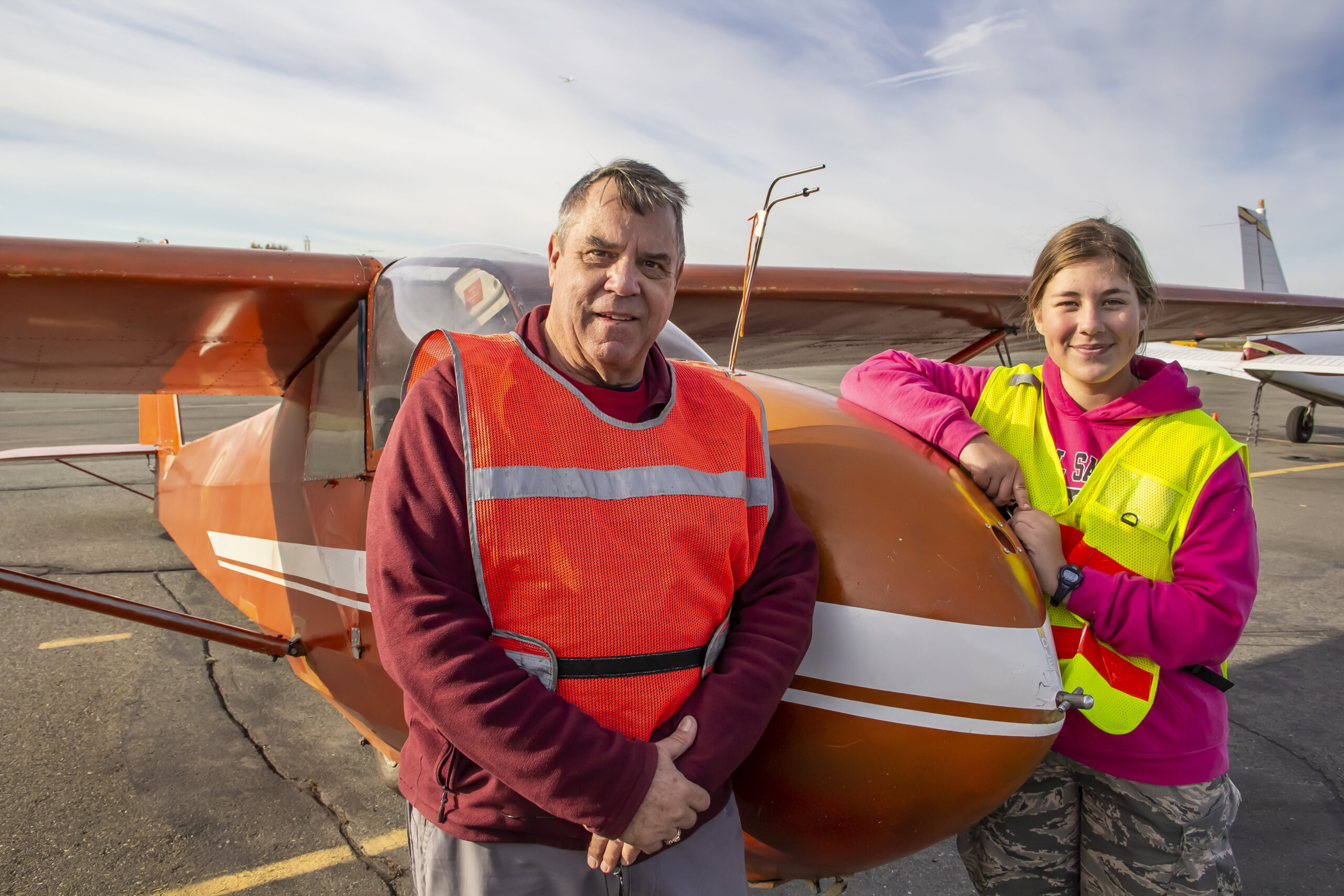 two people an instructor and student standing in front of a glider
