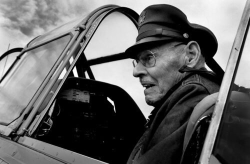 A pilot in the cockpit of a WWII trainer